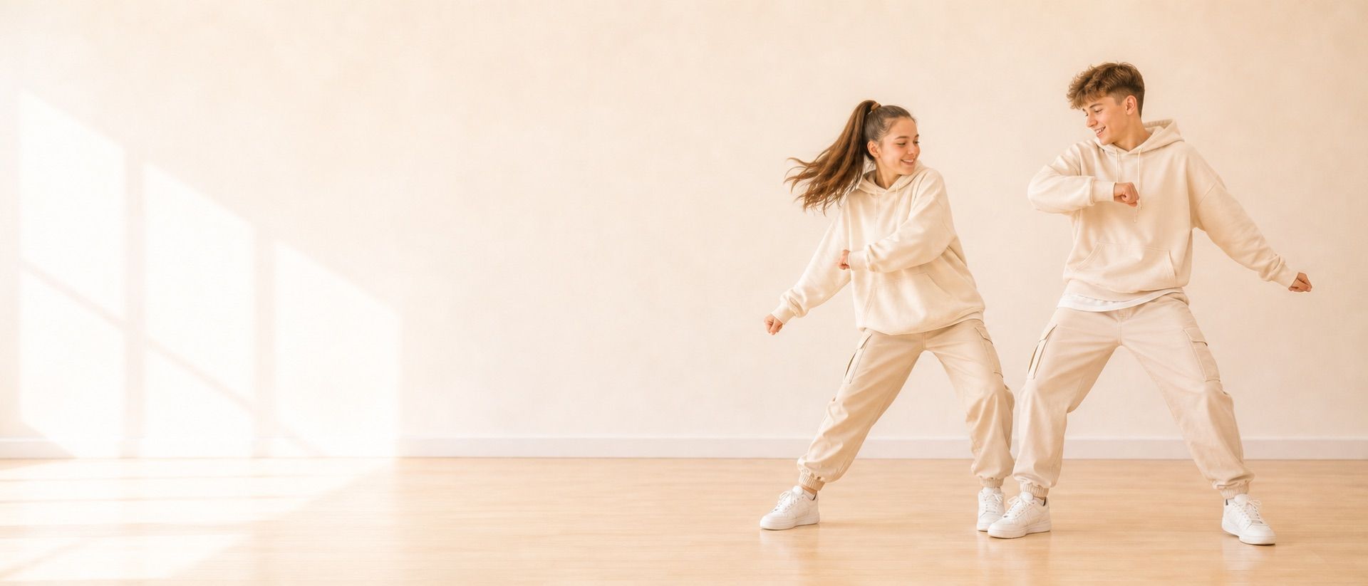 Zwei Kinder oder Jugendliche tanzen fröhlich und altersgerecht in einem hellen Tanzstudio.